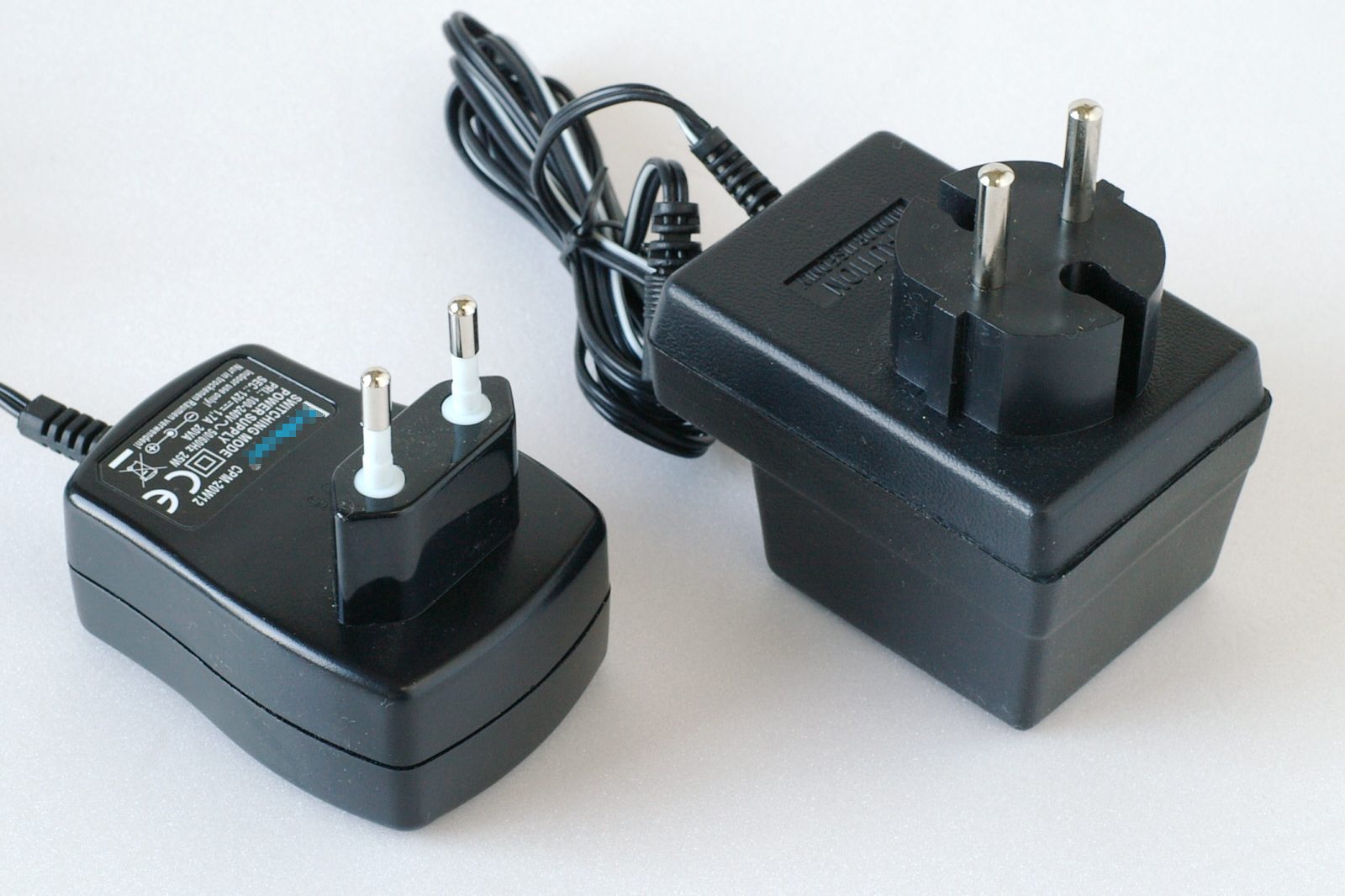 Several mains power adapters of different shapes shown side by side.
